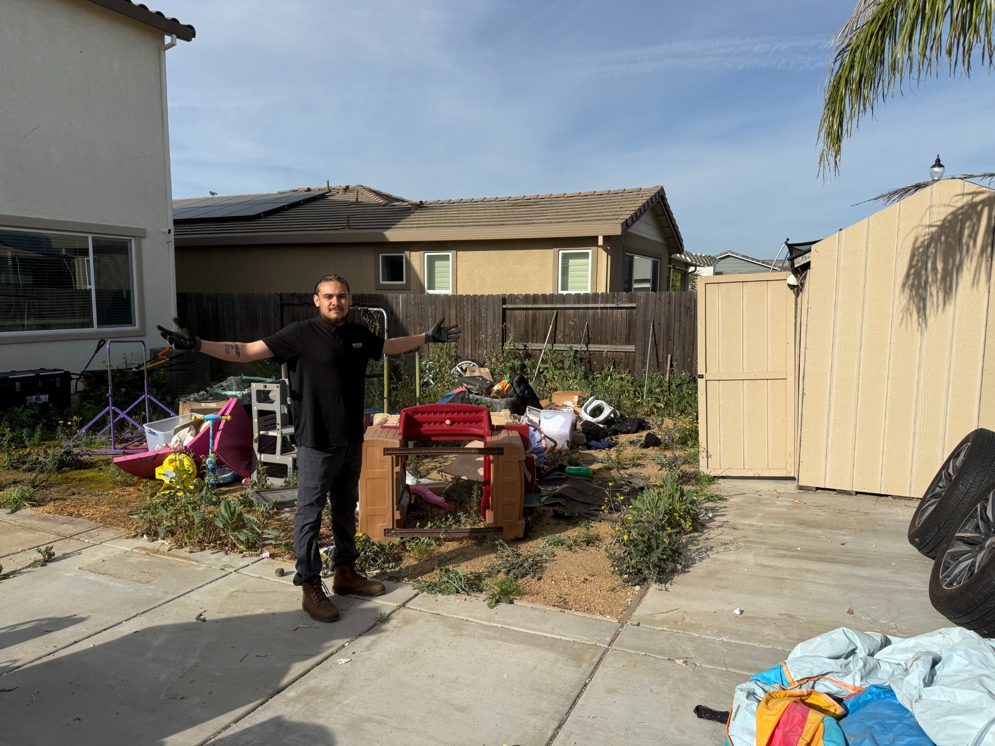 Before yard cleanup in Roseville with weeds, junk, and outdoor debris