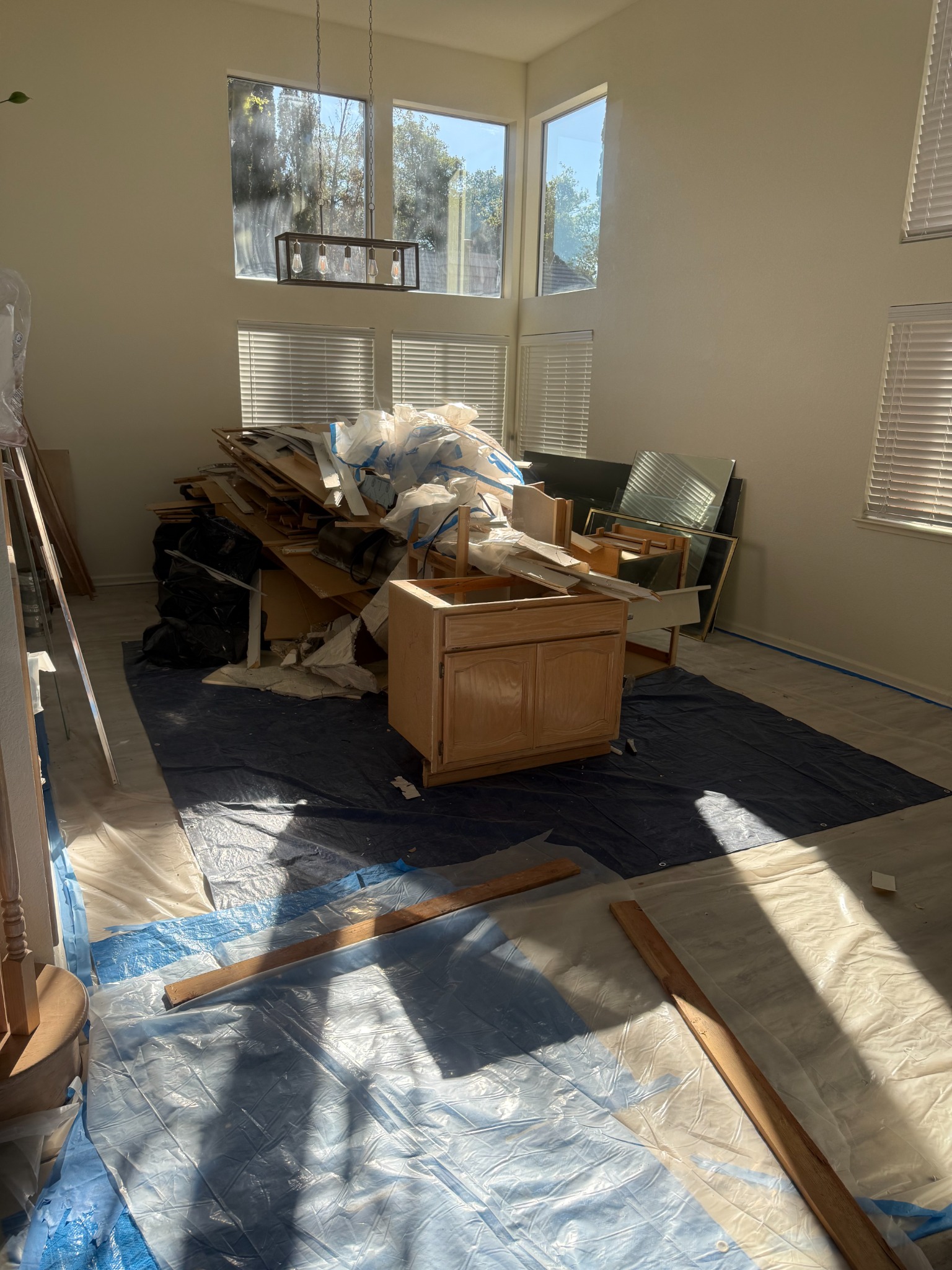 Before demolition cleanout in Sacramento with cabinets and debris piled in a room